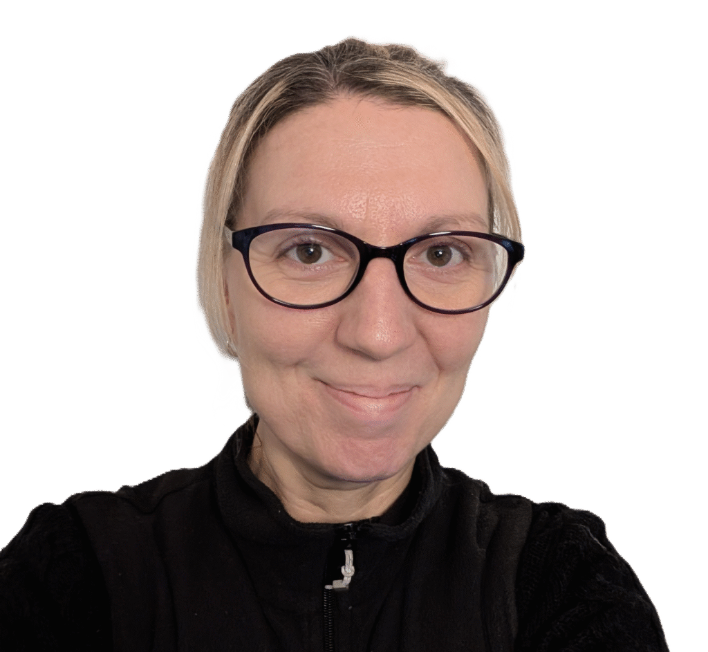 A photo of a white, middle-aged woman wearing glasses smiling slightly.